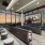 Media room with a large projector screen, three rows of large theater-style armchairs, bar seating, and two full window walls with a panoramic city view