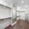 walkin closet with wall mirror and wood rods with shelves