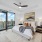 bedroom photo with chair in corner, king size bed, two nightstands and an on suite balcony