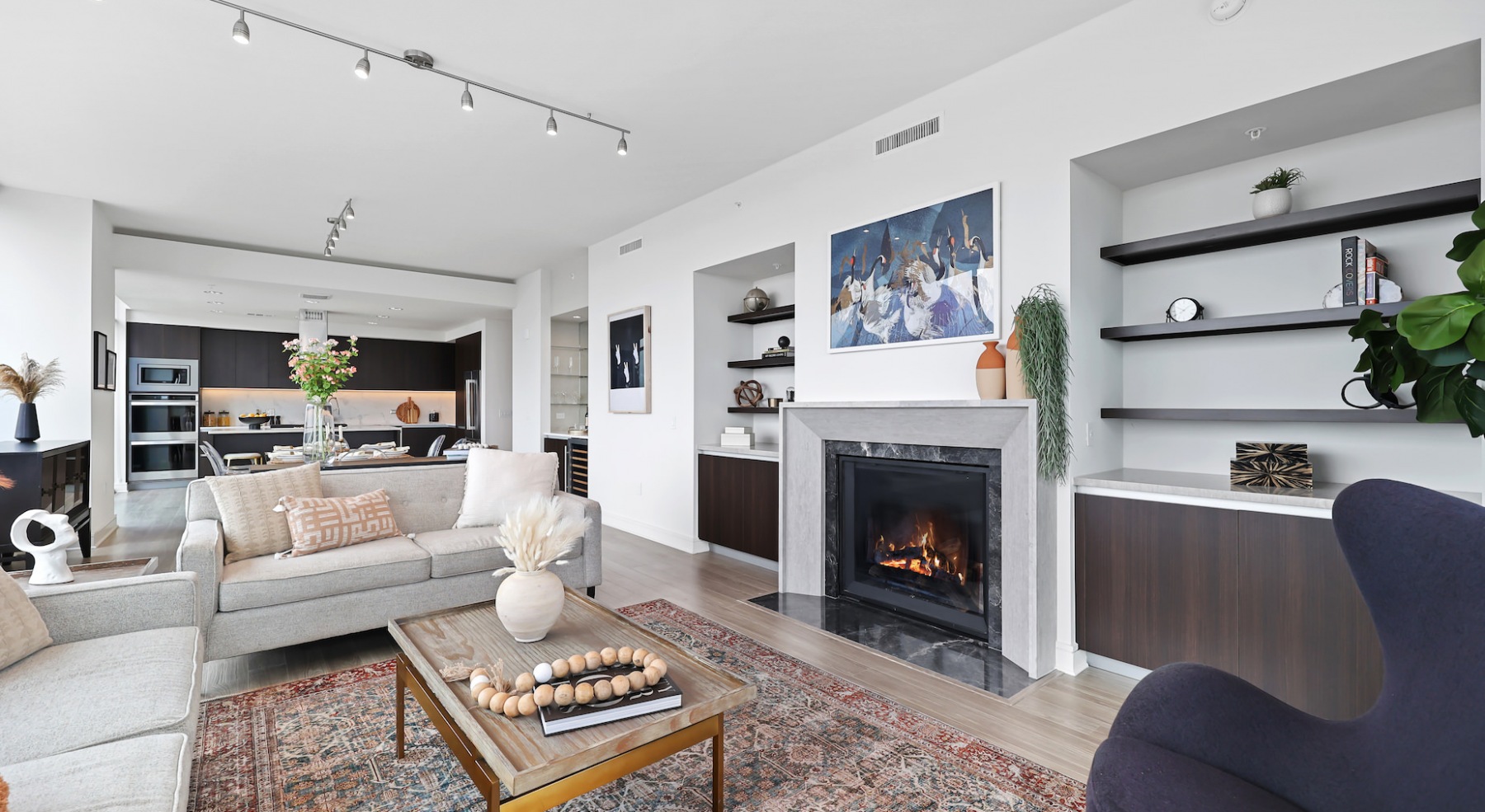 Spacious well lit living room with built-in shelves and fireplace 