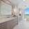 bathroom photo with double vanities, beige countertops and cabinets, with free standing tub 