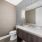 Powder bathroom photo with title backsplash, dark cabinets, and white countertop
